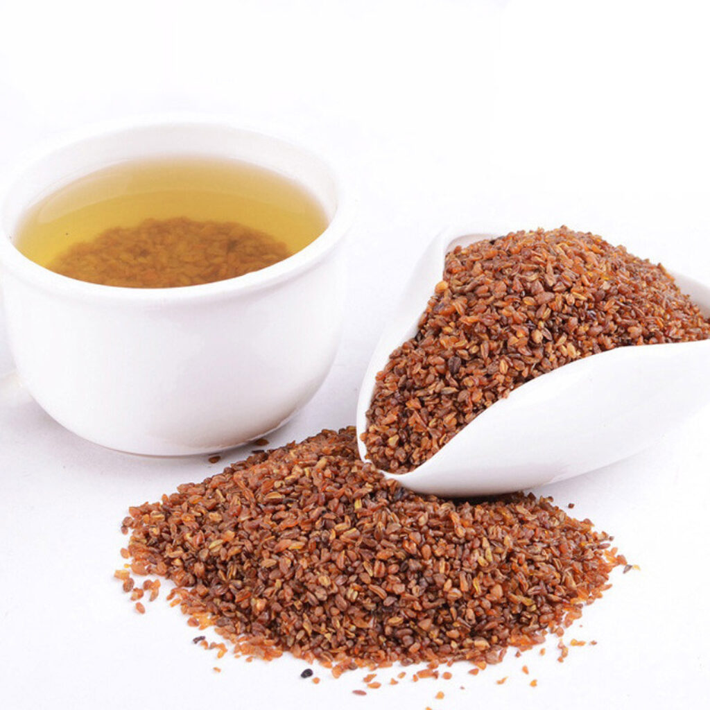 a bowl of brown buckwheat grain next to a cup of buckwheat tea